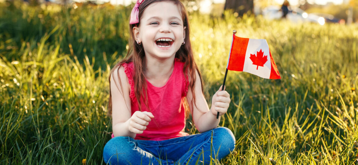 Adorable Cute Happy Caucasian Girl Holding Canadian Flag. Smilin